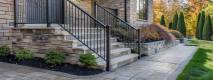 a pristine outdoor setting showcases elegant aluminum picket railings glistening in warm sunlight, accentuating their sleek design and reflecting the beauty of low-maintenance living.
